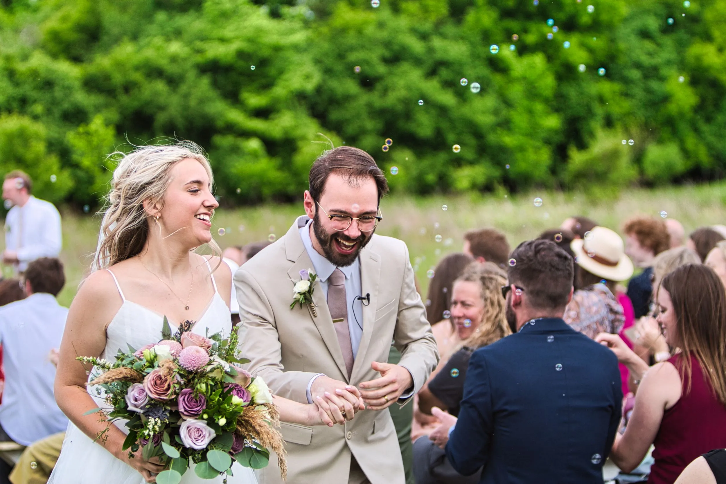 Bride and groom walking up the aisle through bubbles