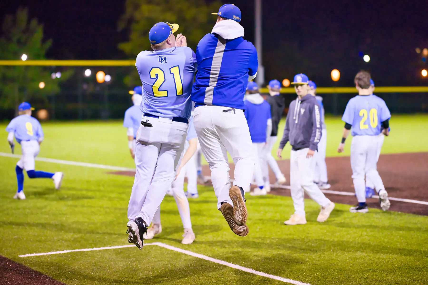 Baseball players leaping in celebration at the plate